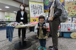 事業所の展示物から作品をもらう子供